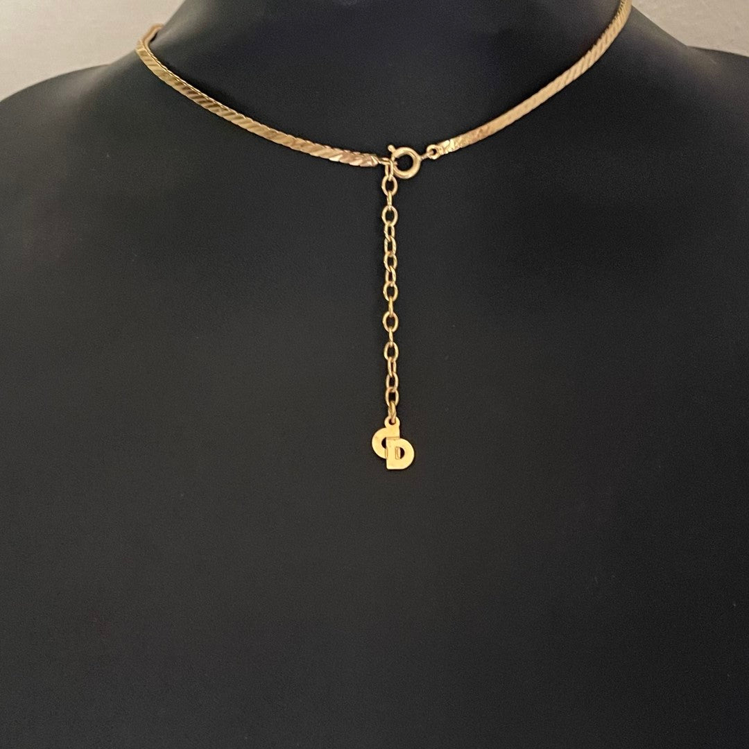 reverse of gold-plated Art Deco style Christian Dior geometric triangle necklace with cream enamel and clear crystal accents showing the lobster clasp and extender chain with CD signature charm.