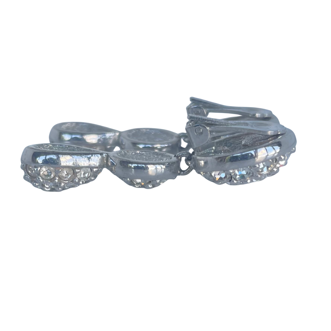 Close-up of a woman wearing vintage 1980s Dior crystal drop earrings with round and teardrop shapes, encrusted with sparkling rhinestones.