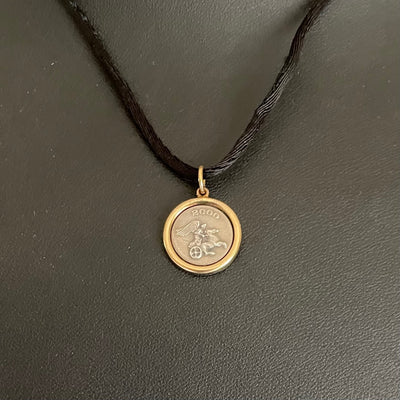 Pristine vintage Ilias Lalaounis necklace showing a 1.6cm 925 sterling silver detailed pendant with an 18K yellow gold border bezel on a 42cm black fabric cord.