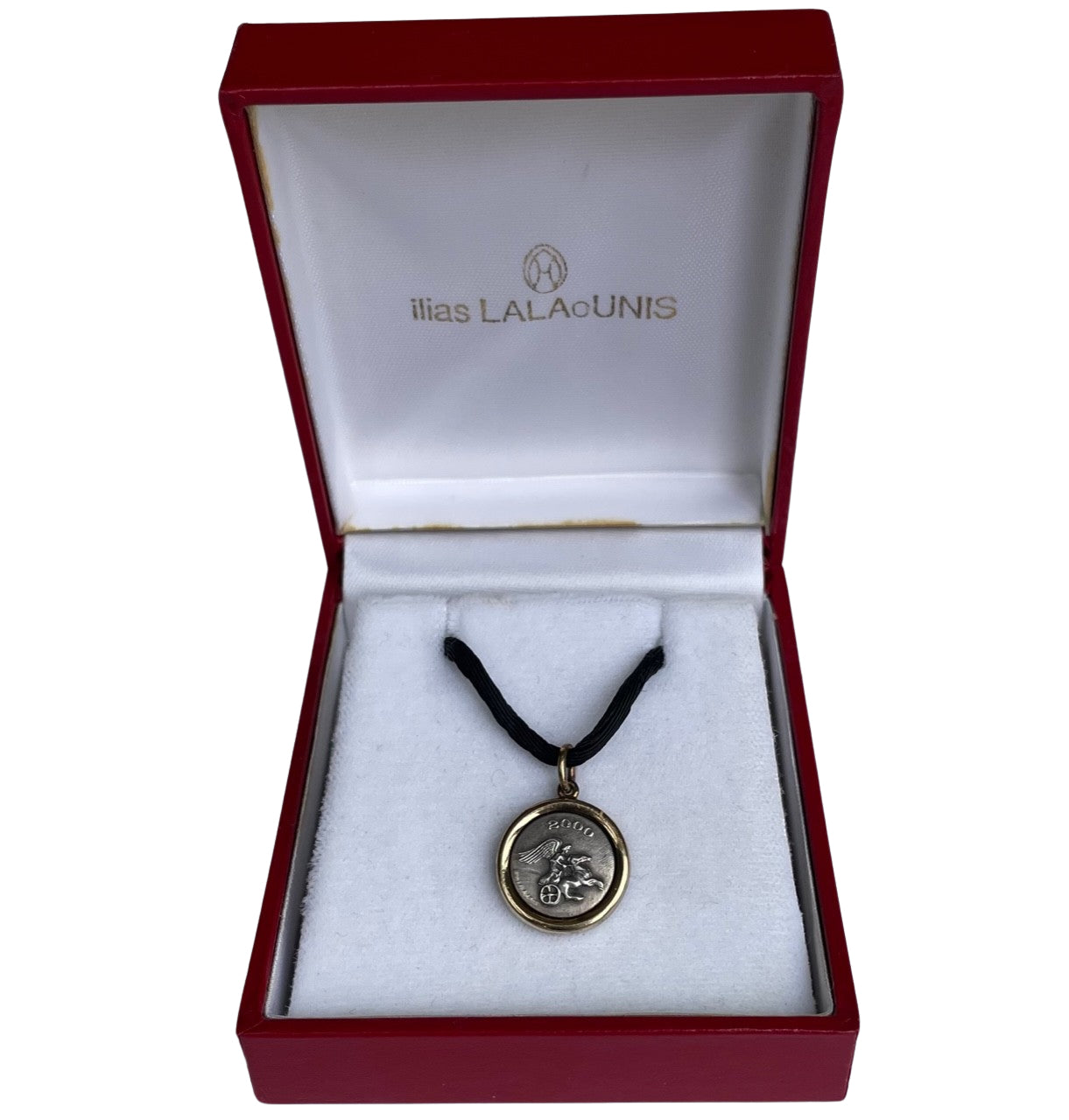 Pristine vintage Ilias Lalaounis necklace showing a 1.6cm 925 sterling silver detailed pendant with an 18K yellow gold border bezel on a 42cm black fabric cord in original Ilias Lalaounis box.