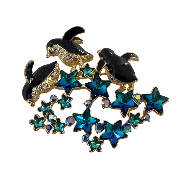 Butler & Wilson brooch with black enamel dolphins leaping over blue crystal stars