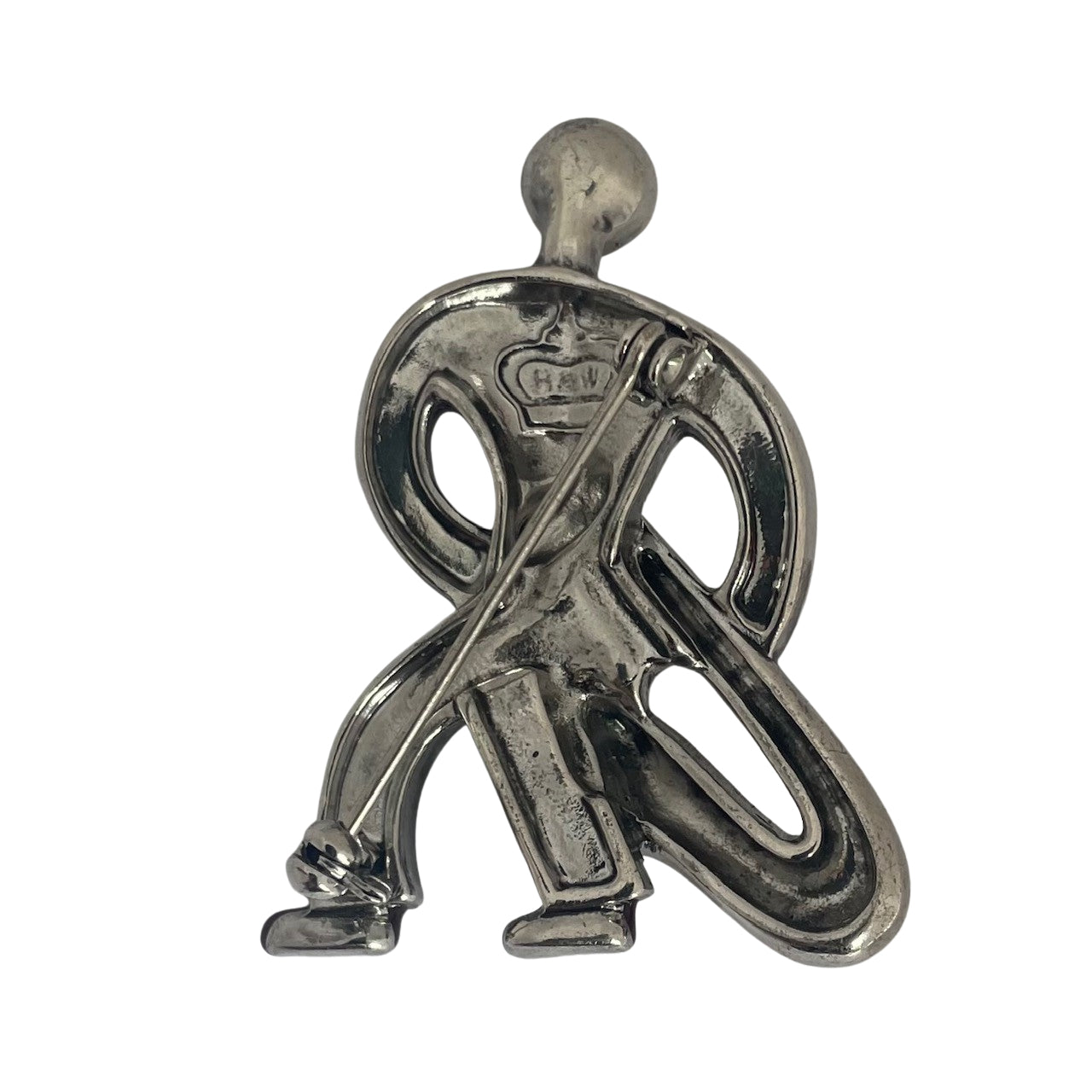 Bacj view of a silver-tone Butler & Wilson Art Deco style saxophonist brooch against a white background, featuring clear rhinestones and red enamel shoes.