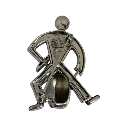 reverse of a silver-tone Butler & Wilson Art Deco style jazz drummer brooch, adorned with clear crystal rhinestones, black enamel, and red enamel shoes. The image shows the Butler & Wilson crown logo and back of pin.