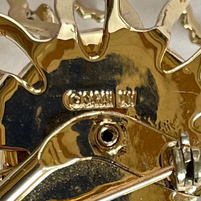 Macro photo of signed ©SARAH COV hallmark stamped on the reverse of a vintage gold brooch