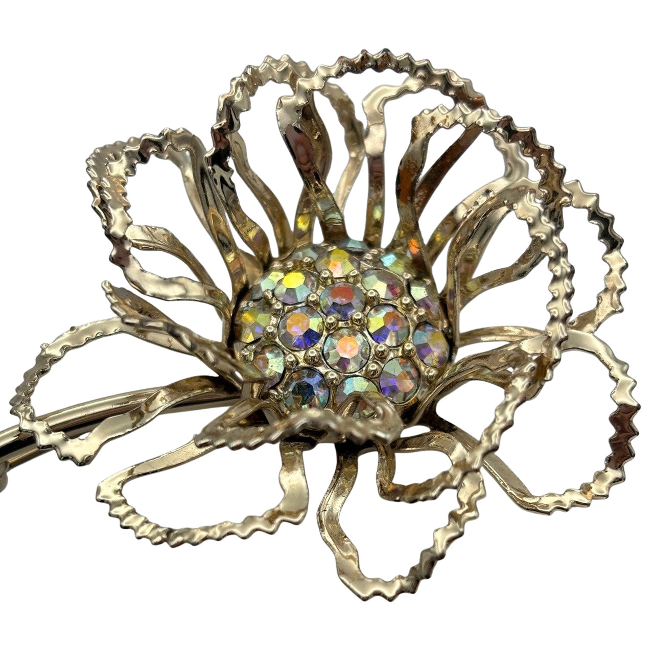 Close-up of iridescent aurora borealis crystals clustered in the centre of a mid-century gold flower pin