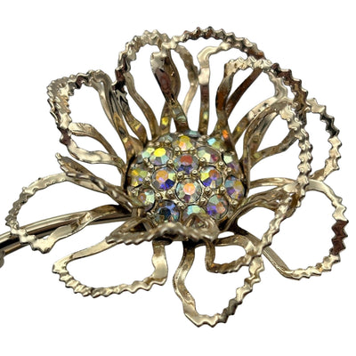 Close-up of iridescent aurora borealis crystals clustered in the centre of a mid-century gold flower pin