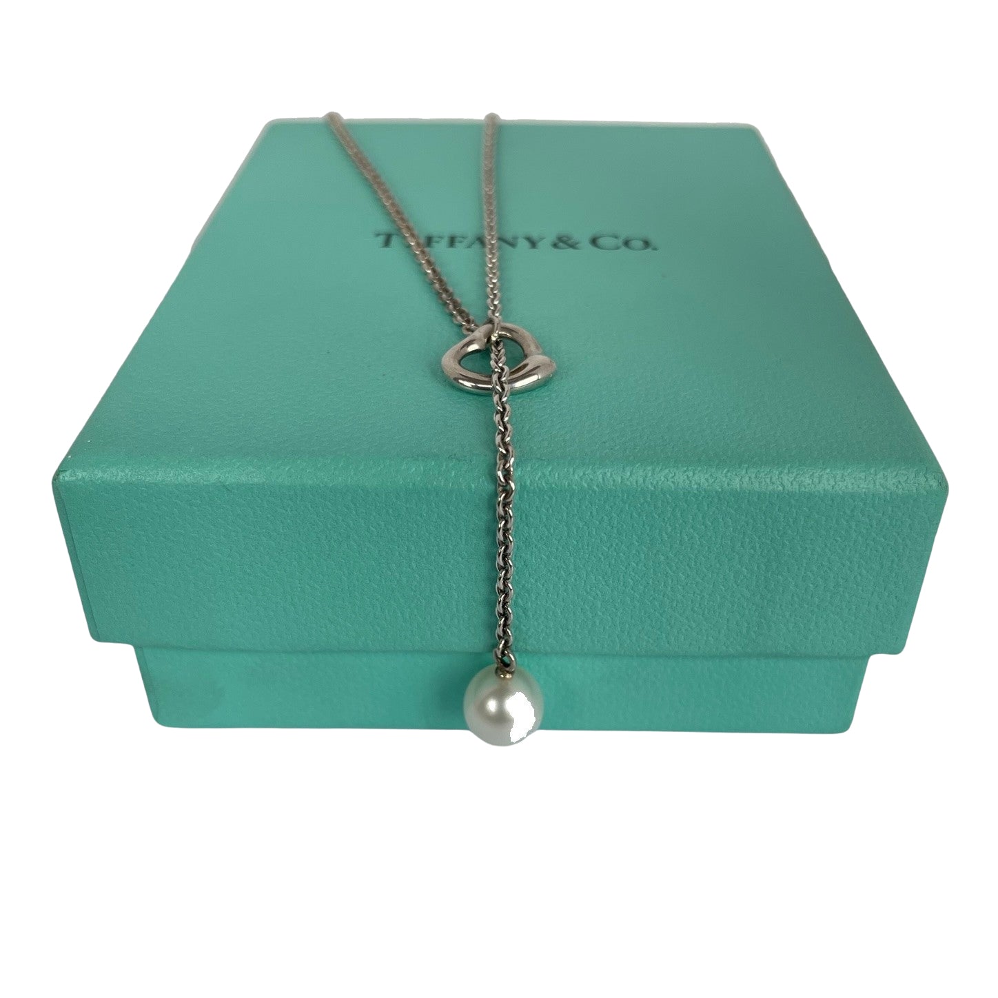 Vintage Tiffany & Co. Elsa Peretti Open Heart sterling silver lariat necklace featuring a sliding open heart pendant and a cultured freshwater pearl on a 19-inch chain, shown in polished pre-owned condition with Tiffany box and pouch.