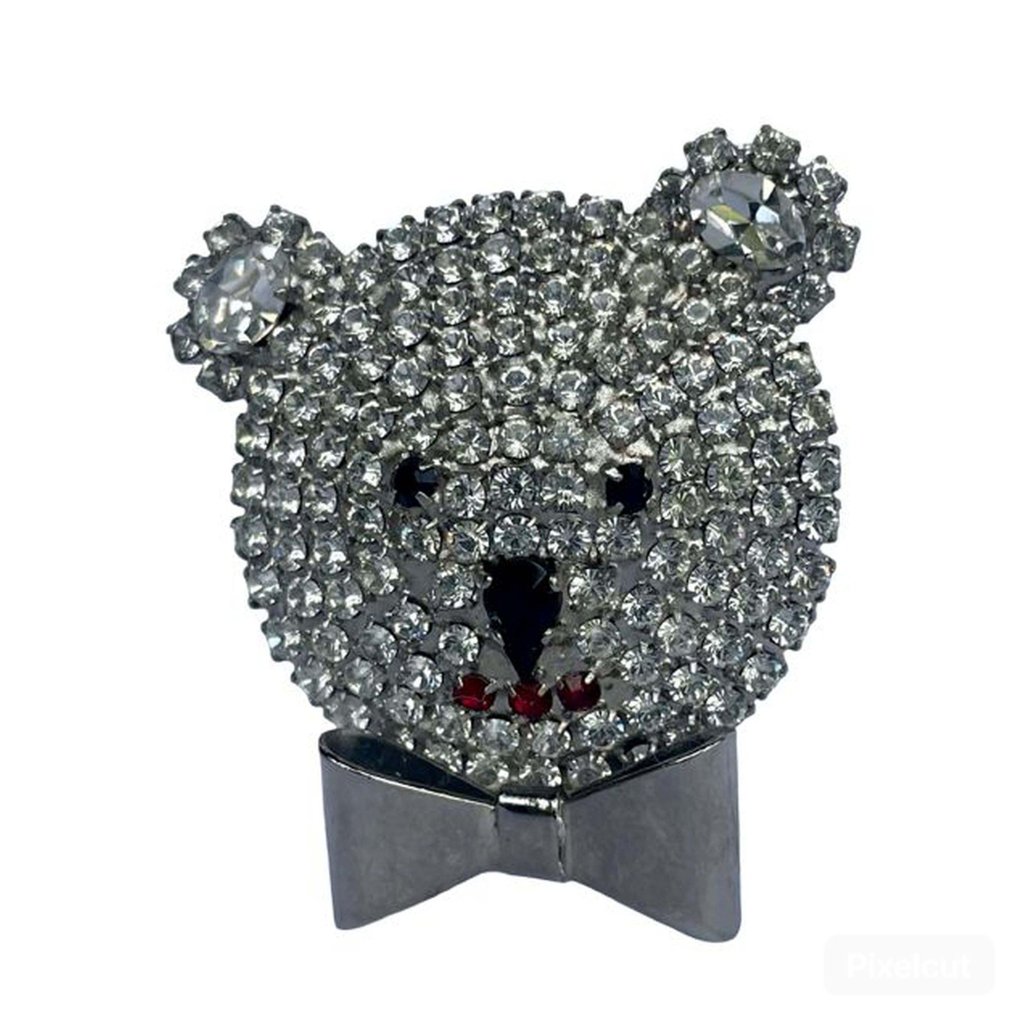 A vintage Butler & Wilson silver-tone teddy bear head brooch pavé-set with clear crystals, featuring black crystal eyes and nose, a three-piece red crystal mouth, and a polished silver bow tie.