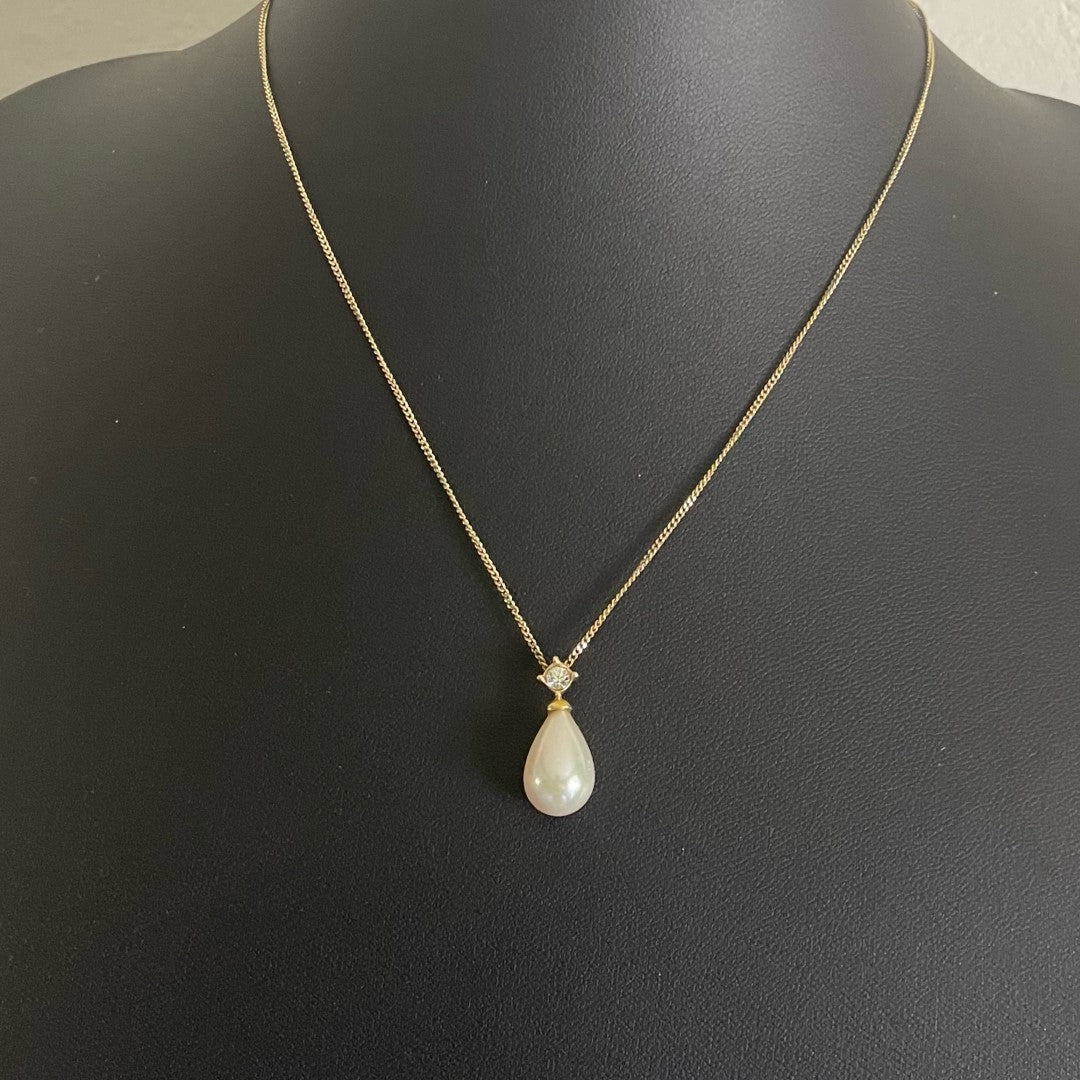 A vintage Christian Dior gold tone necklace with a tear drop faux pearl pendant topped with a sparkling Swarovski crystal.