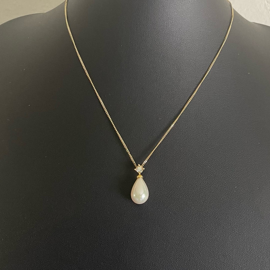 A vintage Christian Dior gold tone necklace with a tear drop faux pearl pendant topped with a sparkling Swarovski crystal.