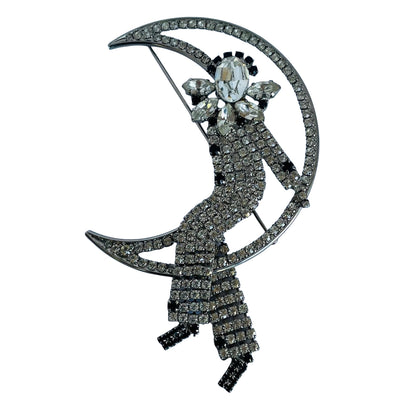 Large vintage 1980s Butler and Wilson crystal Harlequin Pierrot on moon brooch on white background.