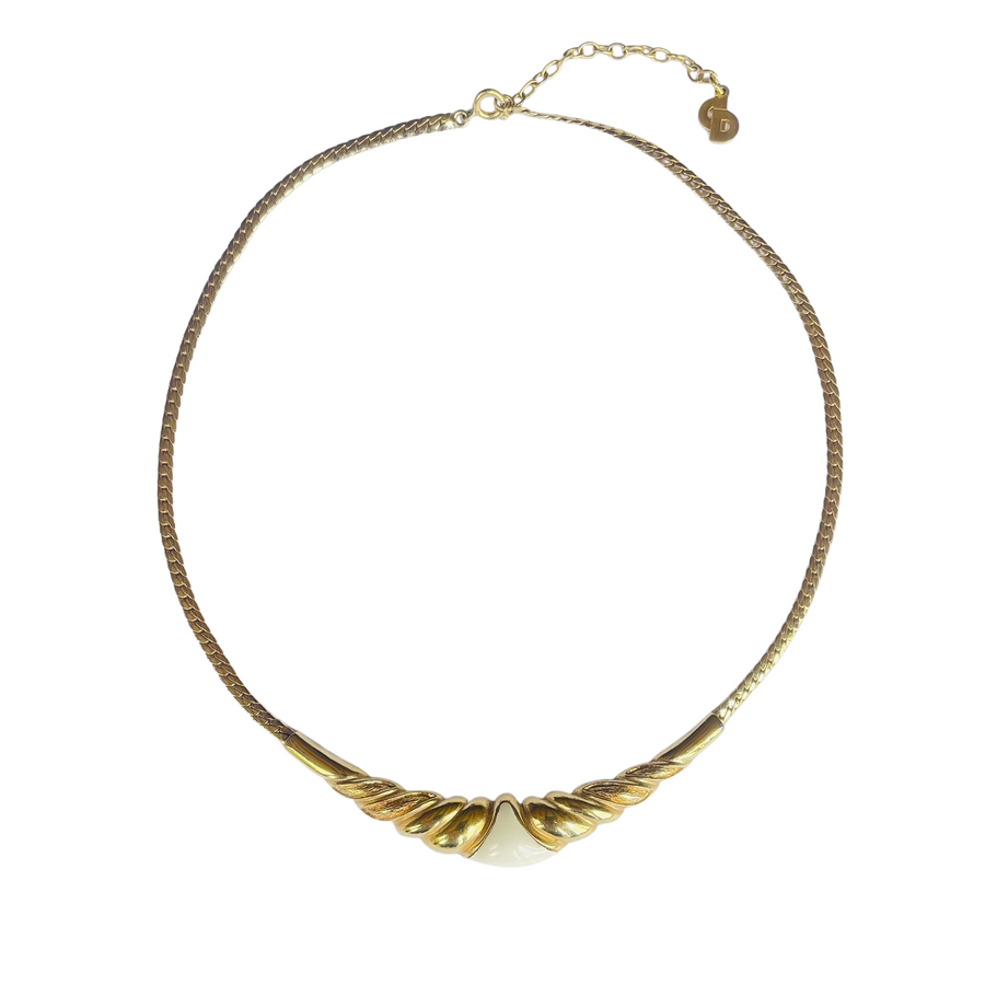 Vintage 1980s Christian Dior gold-plated collar necklace featuring a fluted centerpiece, cream enamel shield insert, and signed CD charm. Excellent condition.