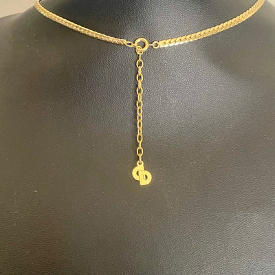 Close-up of the reverse side of a vintage Christian Dior necklace charm, showing the official Chr.Dior copyright signature hallmark stamp.