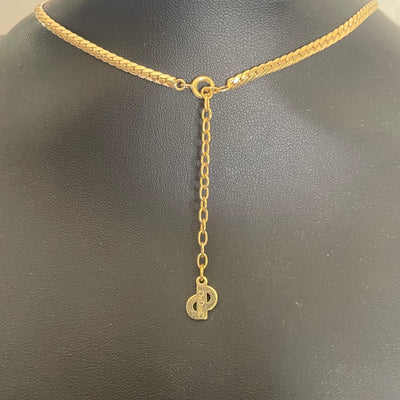Close-up of the reverse side of a vintage Christian Dior necklace charm, showing the official Chr.Dior copyright signature hallmark stamp.