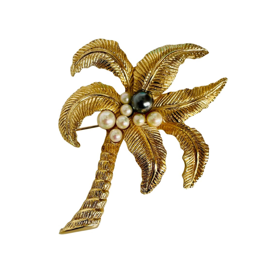 Vintage Christian Dior Gold palm tree brooch with luminescent pearls nestled at its centre.
