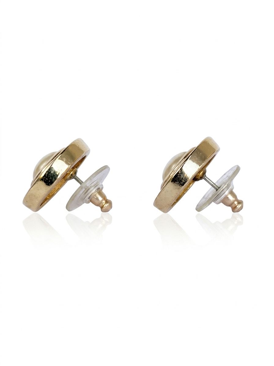The side of a pair of vintage Christian Dior gold-plated earrings, showing the straight post backings for pierced ear and the silicone backs.