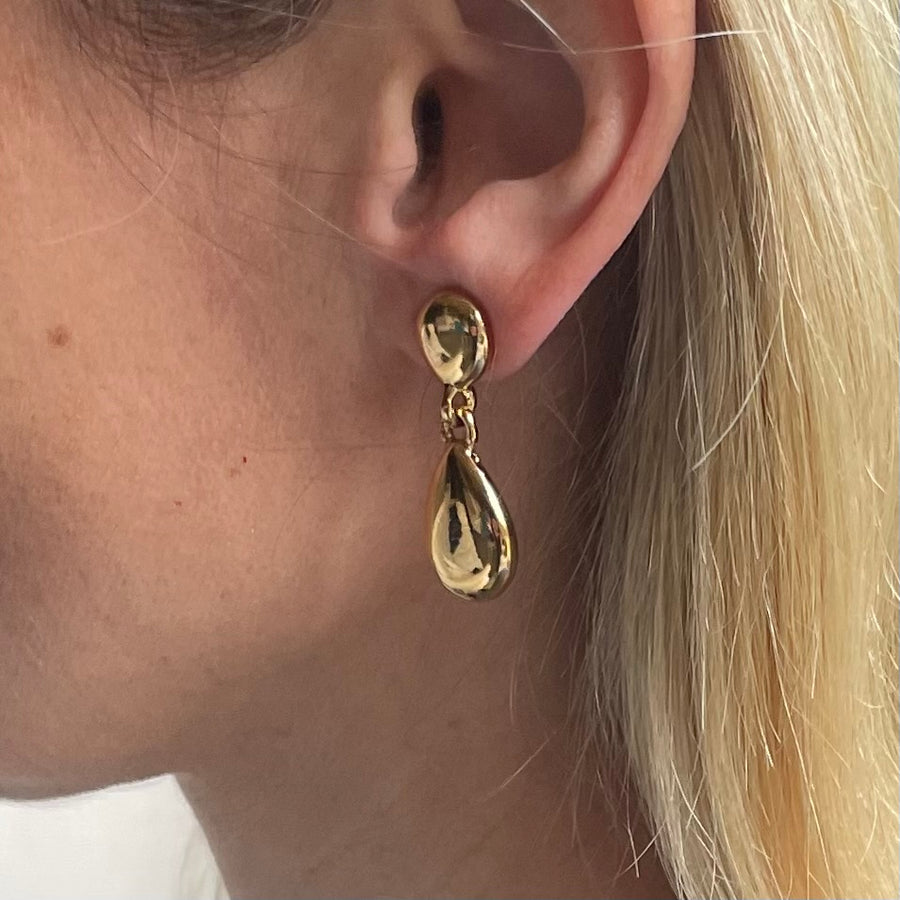 Pair of vintage Givenchy gold teardrop dangle clip-on earrings shown on model