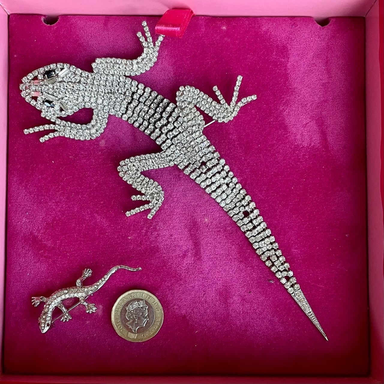 A magnificent 19 cm vintage Butler & Wilson silver-tone articulated lizard brooch encrusted with clear crystals and black eyes, shown in its Butler & Wilson pink box with a small lizard and £1 coin for scale