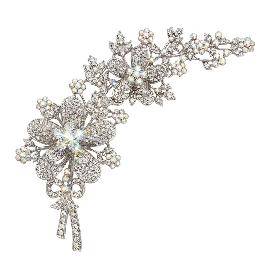 A large silver-tone Butler & Wilson floral corsage brooch on a white background, featuring trailing flowers and a sparkling bow detailed with clear and iridescent Aurora Borealis crystals.