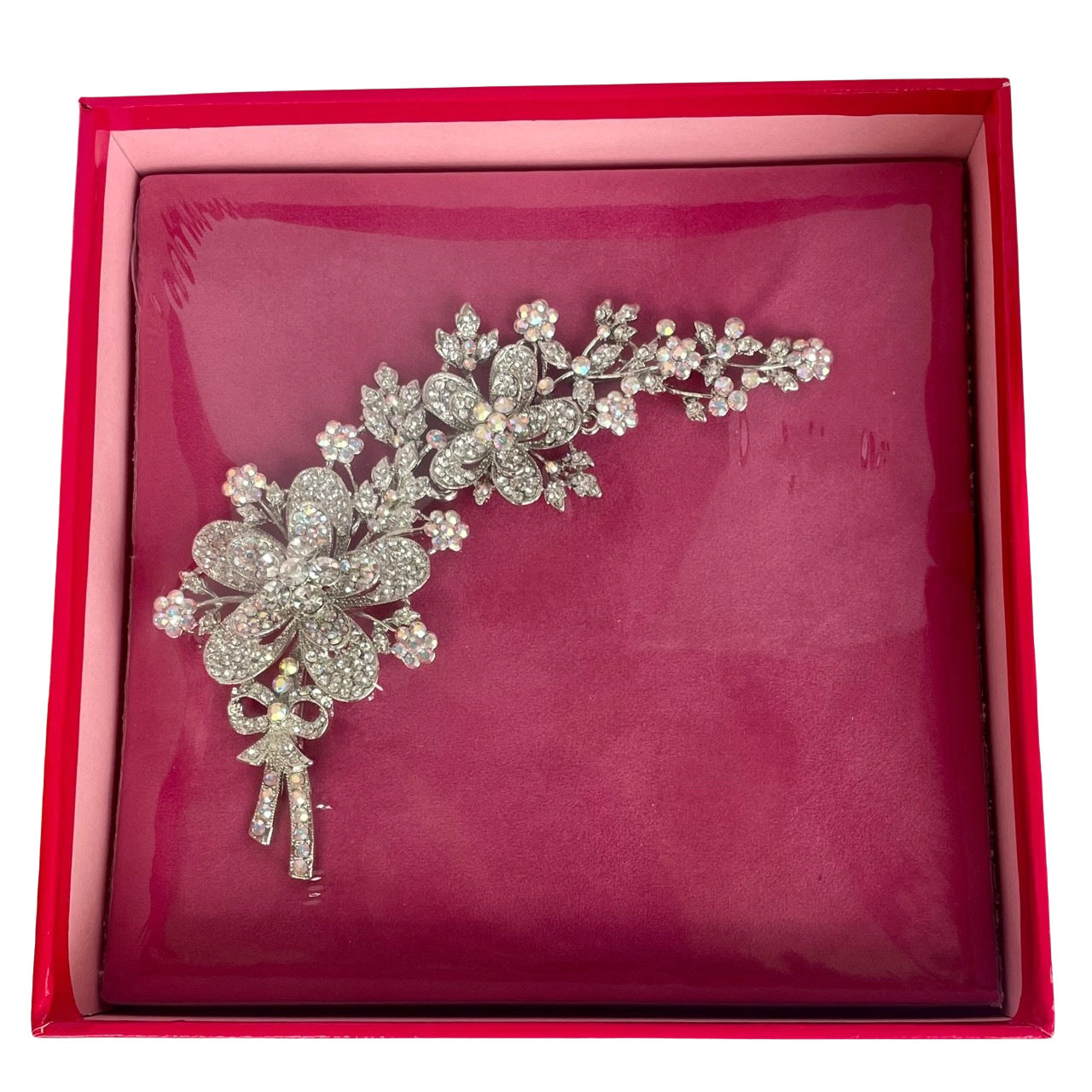 A large silver-tone Butler & Wilson floral corsage brooch on a white background, featuring trailing flowers and a sparkling bow detailed with clear and iridescent Aurora Borealis crystals still sealed in original pink Butler & Wilson box,
