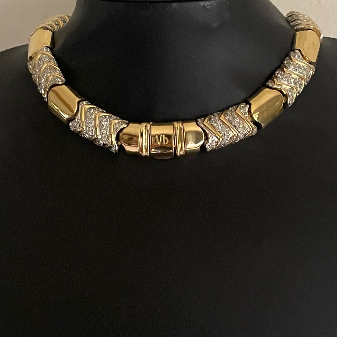 vintage Vogue Bijoux gold-tone collar necklace with pavé crystal chevrons displayed on a black mannequin bust, highlighting the prominent "Vb" stamped clasp at the front centre