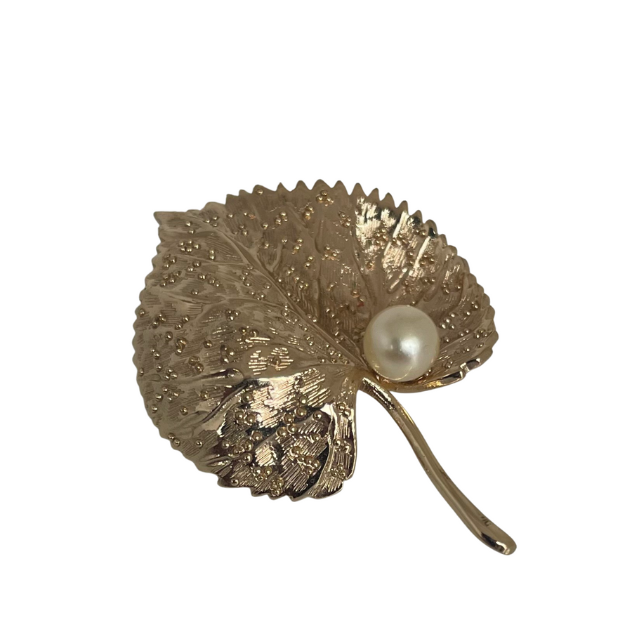 Christian Dior 1980s vintage brooch featuring a gold-tone textured leaf design with a single faux pearl accent.